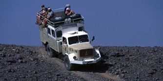 Afrika, West-Sahara, Algerien: Die Reisenden genieen whrend der Fahrt die Aussicht vom Dach des LKWs.